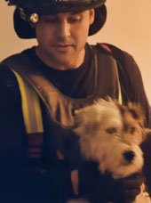 Firefighter holding adorable scraggly dog