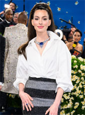 Anne Hathaway at the Met Gala in a white shirt and sequin skirt