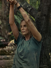 Still from Apex of Charlize Theron with her hands tied above her head
