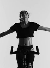 Black and white image of a fit woman on a bike via Soulcycle on YouTube
