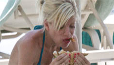 Tori Spelling in a bikini eating a sandwich