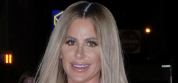 Kim Zolciak poses for a pic next to two of her kids sleeping in hospital beds