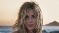 Jennifer Aniston sits on some rocks to sell her new perfume, Lolavie