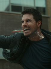 Robbie Amell using his superpowers with a glowing vein in his neck in a still from Code 8