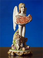 Kitschy statue of an angel with long blonde hair holding up a steak
