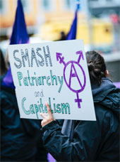 A Smash Patriarchy and Capitalism sign at a protest